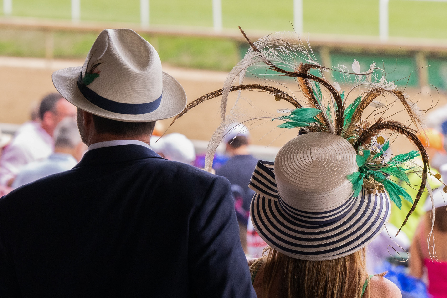 Kentucky derby hats with people watching racetrack